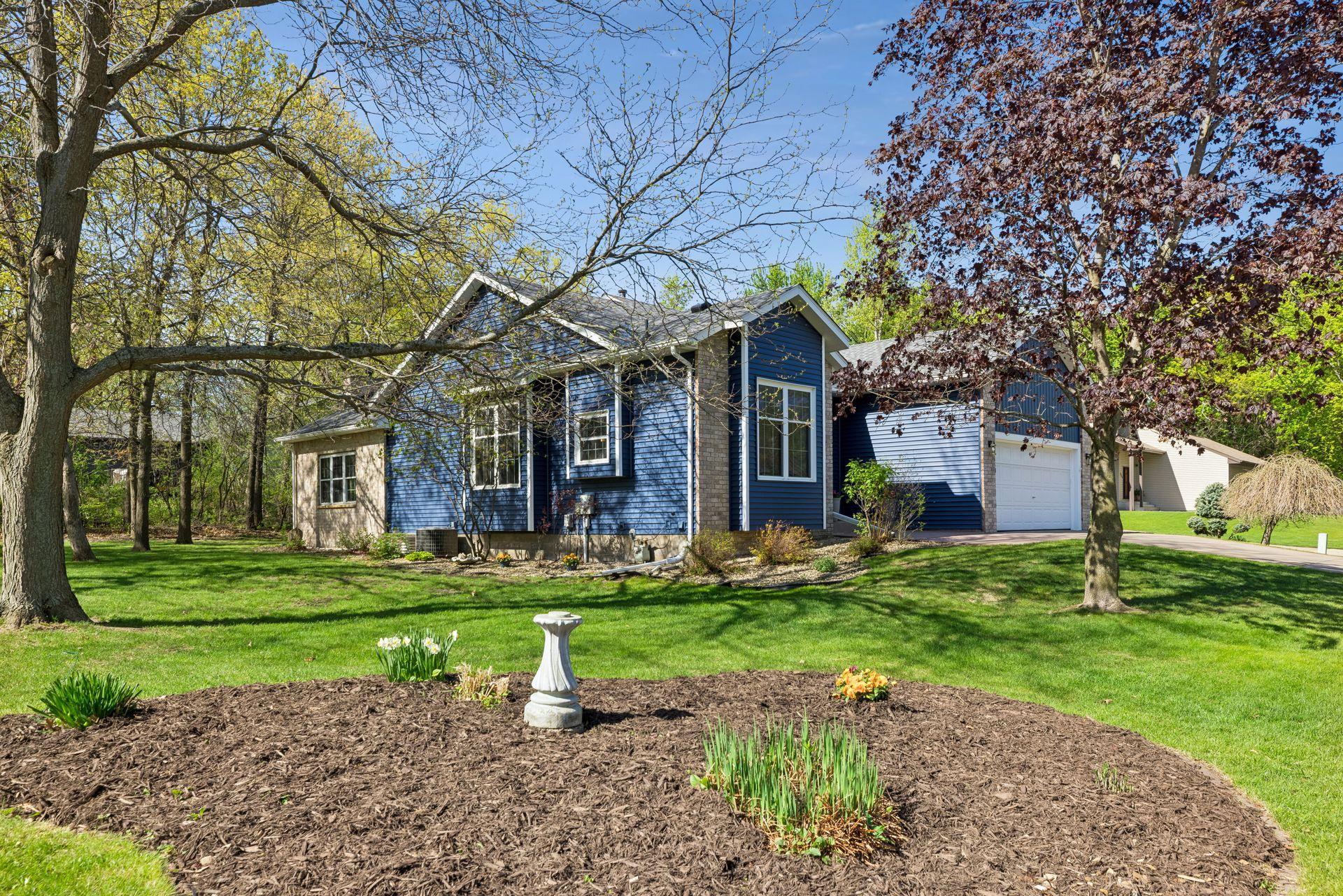 Garden beds are placed throughout the yard, there are some raspberry bushes growing behind the garage too.