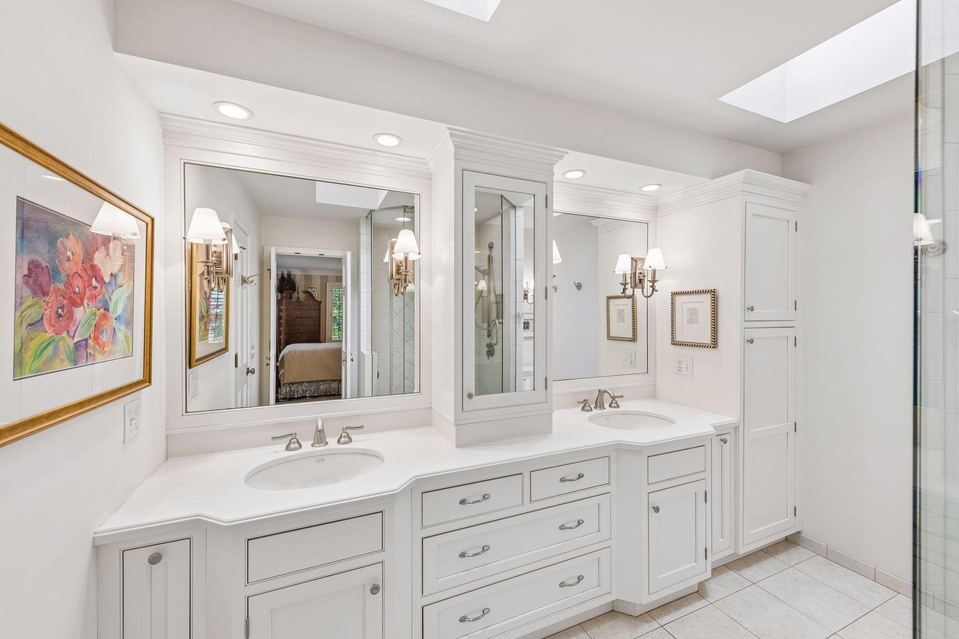 Primary bathroom with dual sinks, double vanities, and walk-in closet