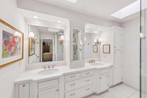 Primary bathroom with dual sinks, double vanities, and walk-in closet