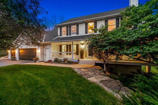 Photo for 22412 Wagon Wheel Trail, Lakeville, MN 55044 - listing #7072286 Striking twilight view of 22412 Wagon Wheel Trail, showcasing the home’s inviting wraparound porch, beautiful landscaping and picturesque setting.