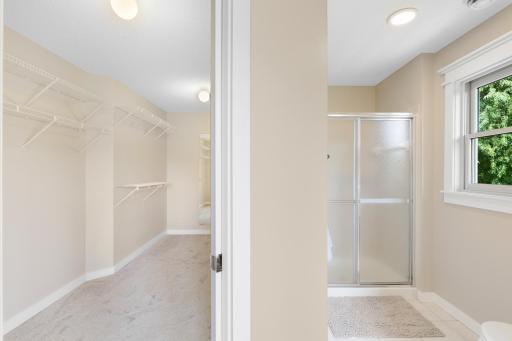 Spacious primary walk-in closet conveniently connected to the private bath, offering abundant storage and easy access to the separate shower.