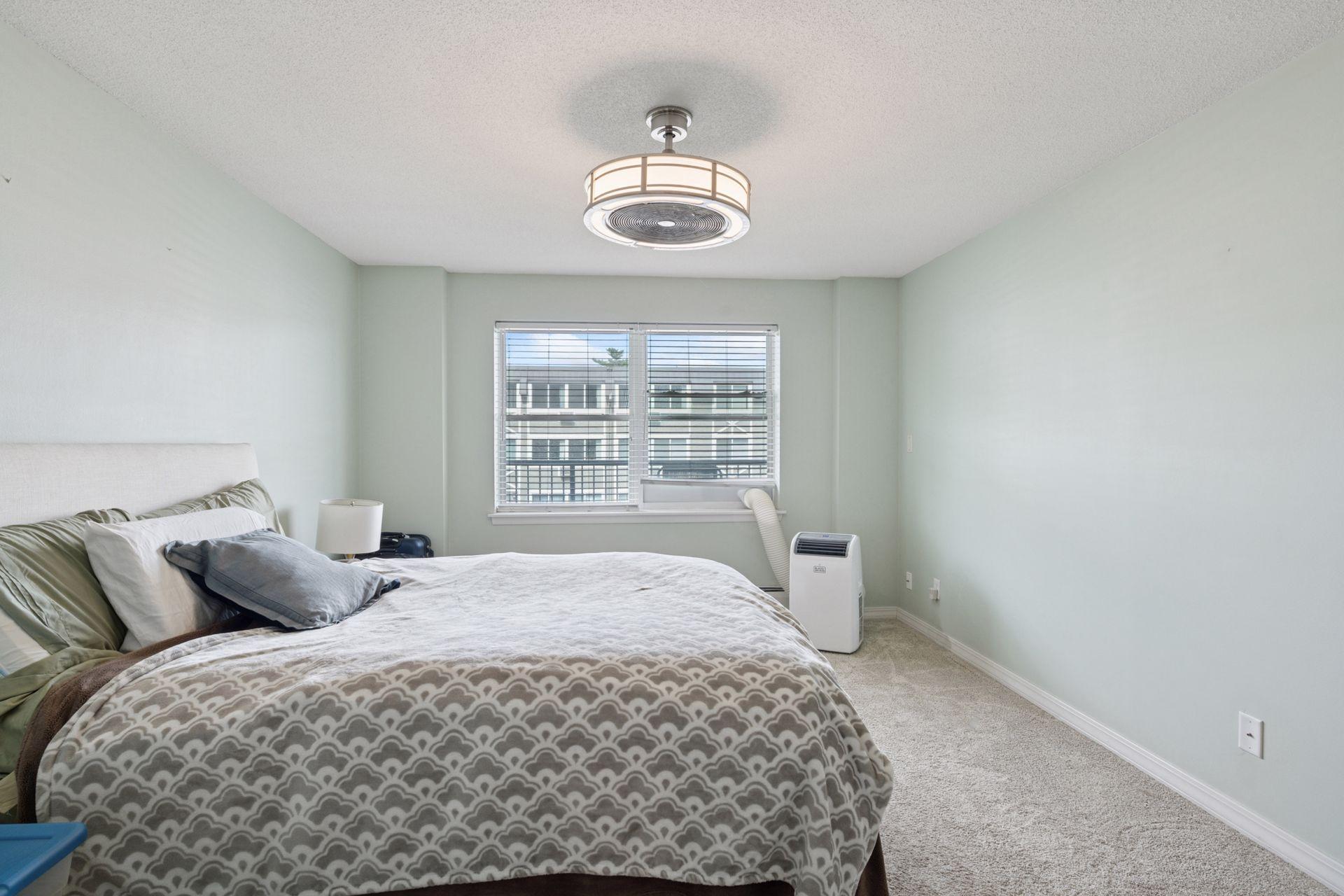 Spacious primary bedroom with abundant natural light and a calm, neutral palette—just minutes from Lake Bde Maka Ska, trails, and Uptown dining.