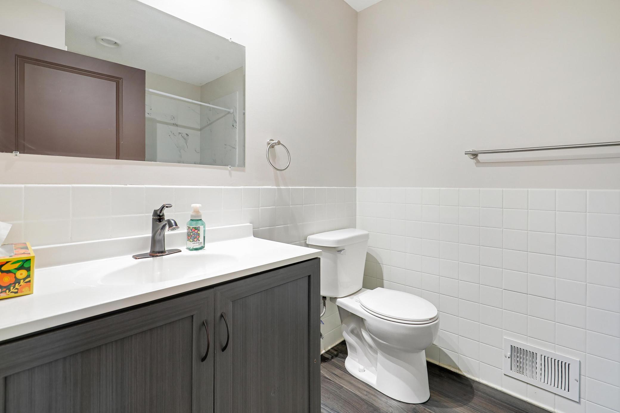 Lower level 3/4 bath with updated vanity and flooring.