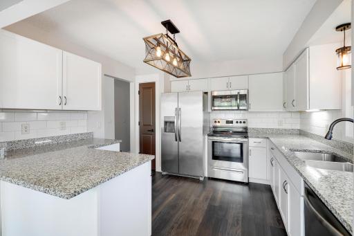 The kitchen features stone countertops and a classic subway tile backsplash.