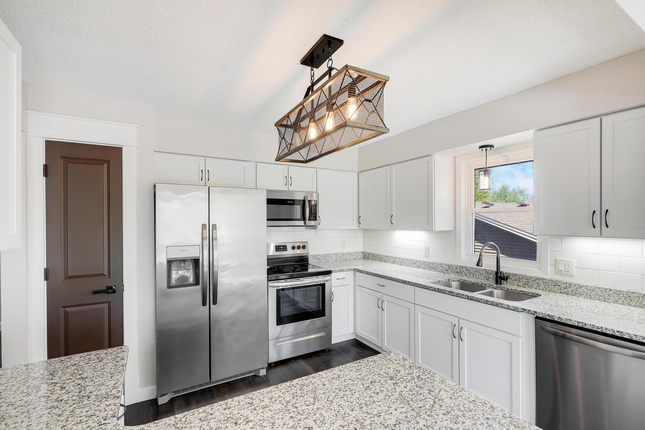 The kitchen is equipped with newer stainless steel appliances.