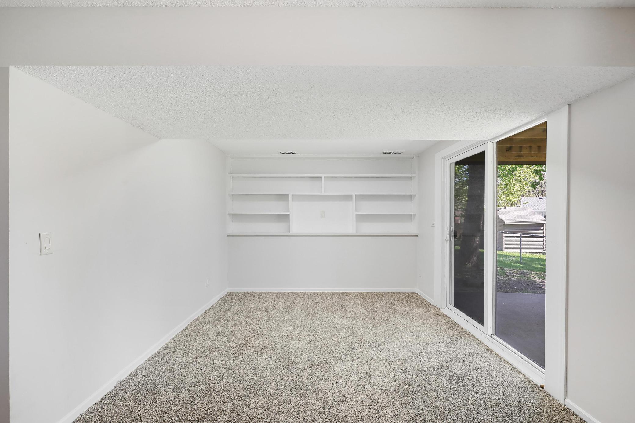 The lower level family room extends with a built-in bookcase, adding both character and functional storage.