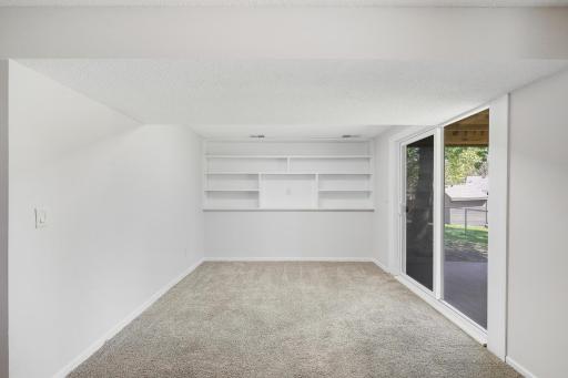 The lower level family room extends with a built-in bookcase, adding both character and functional storage.