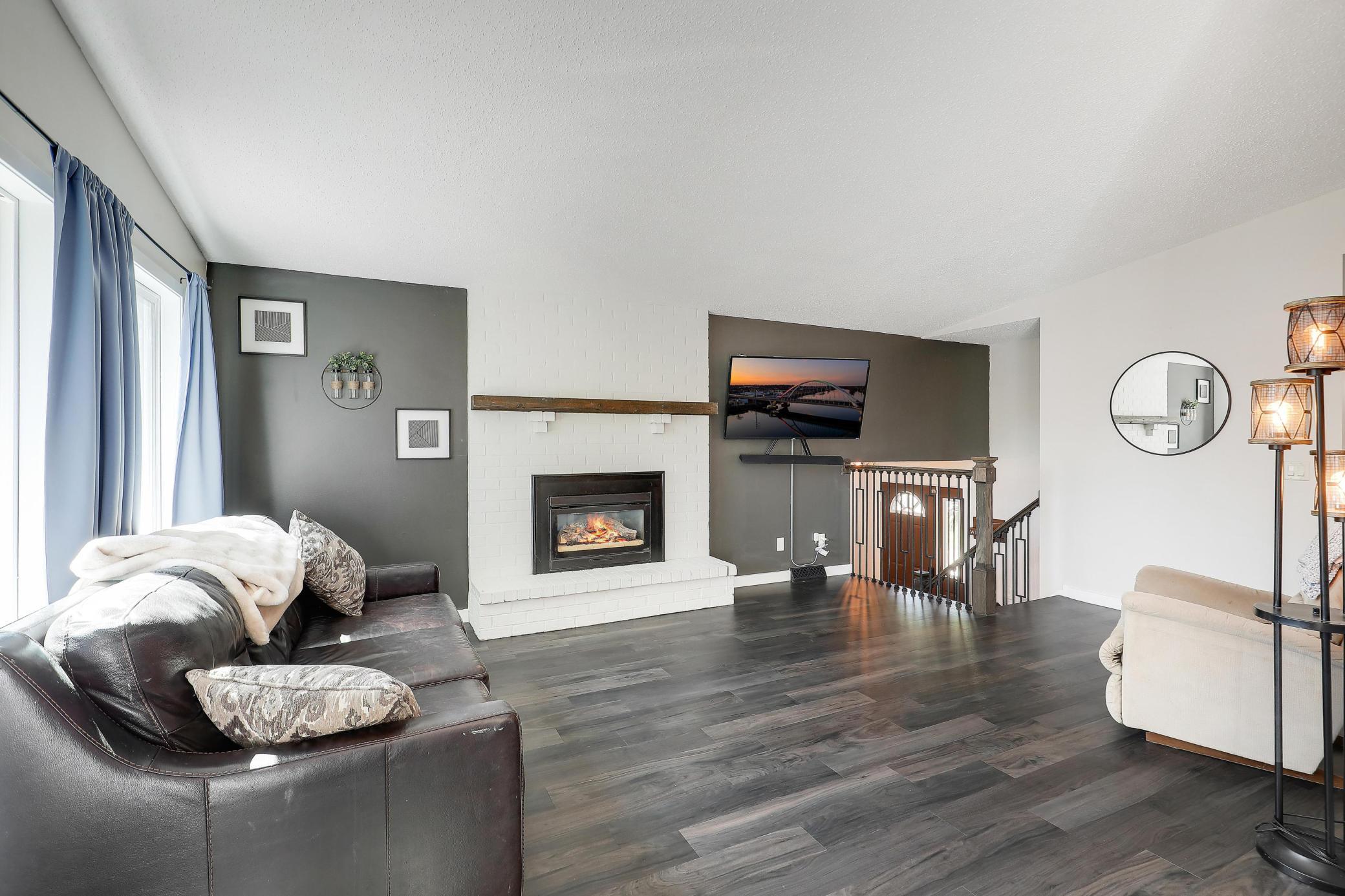 The living room showcases modern finishes and a cozy gas fireplace.