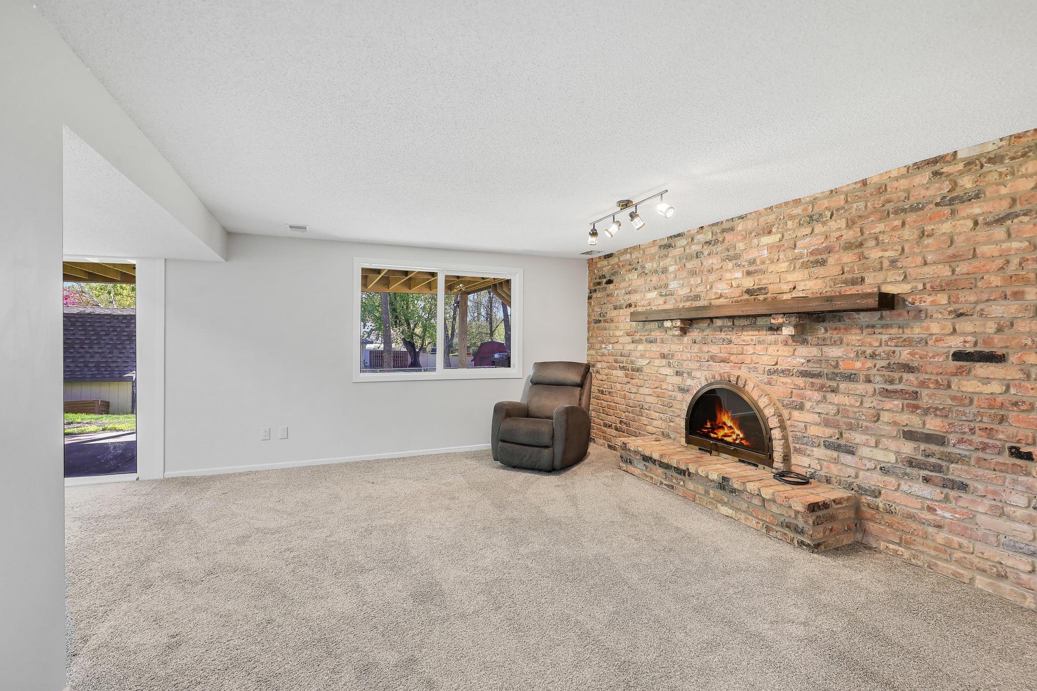 The lower level family room offers a cozy wood-burning fireplace, perfect for relaxing evenings.