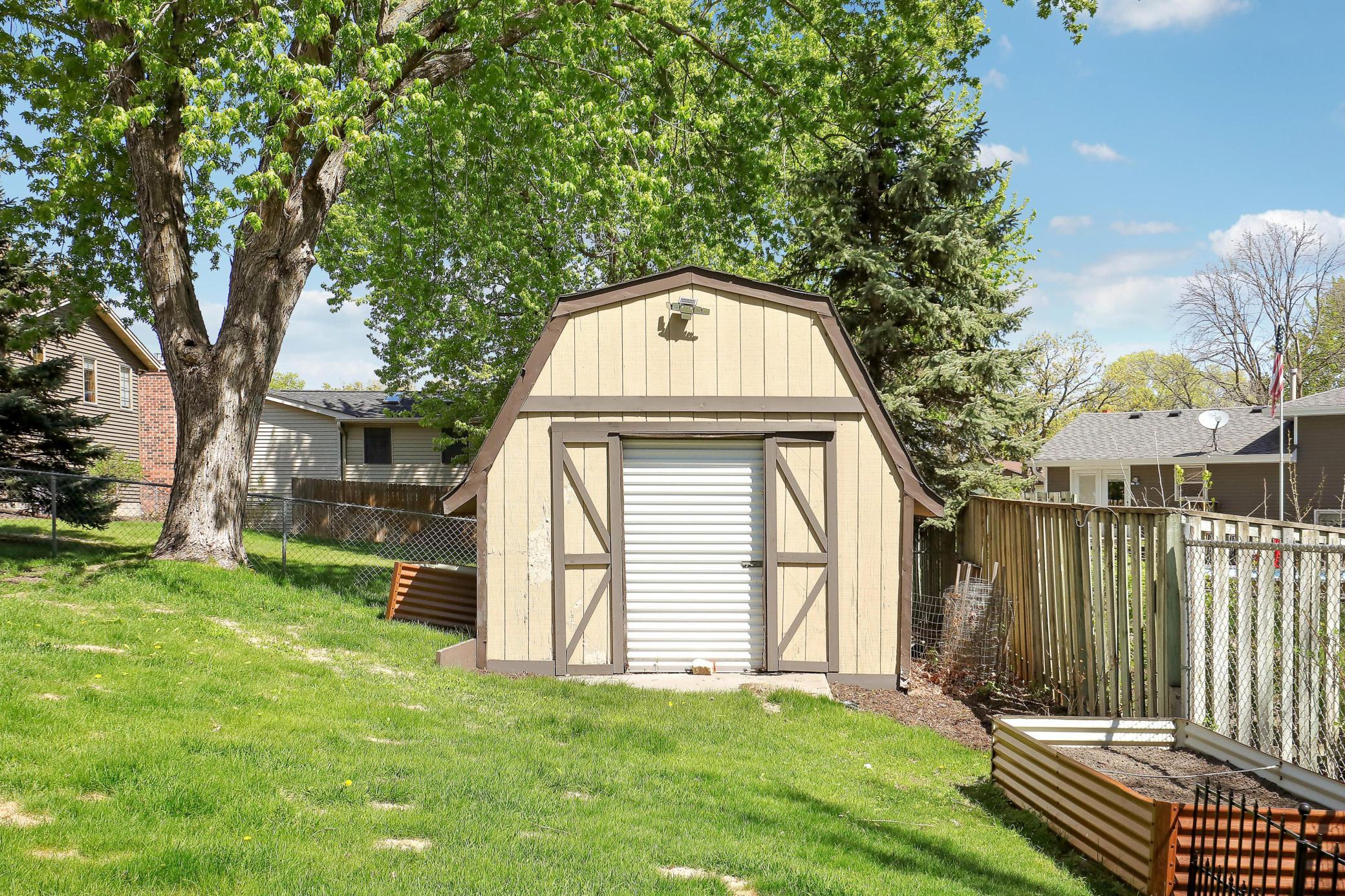 A storage building provides additional space for tools, equipment, and seasonal items.