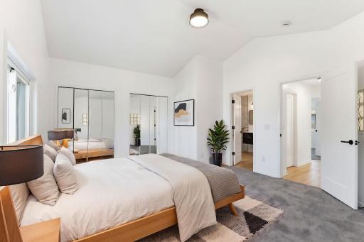 Spacious primary bedroom with vaulted ceilings, abundant natural light, and a bright, airy layout The generous room size offers flexibility for a sitting area or additional furniture. Virtually staged.