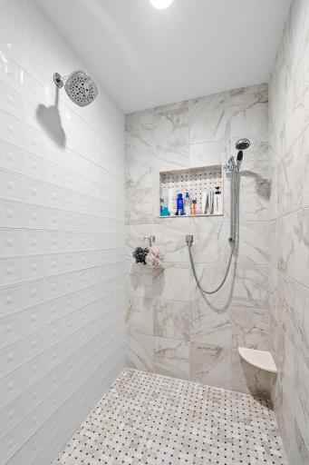 Luxurious Primary Suite w/ auto blinds, spa-like Bath w/ heated floors, freestanding tub, dual vanities & oversized WIC w/ organizational system + pass-through access to Laundry