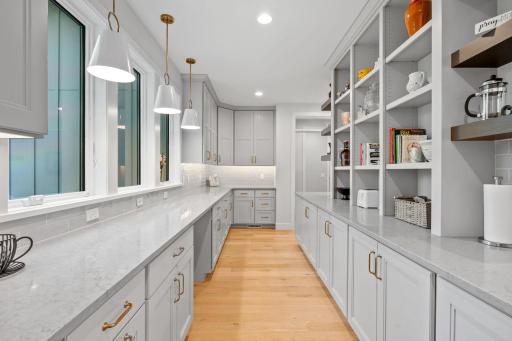 Open Prep Kitchen w/ addtâl custom cabinetry, beverage fridge, pocket Office & floating shelving