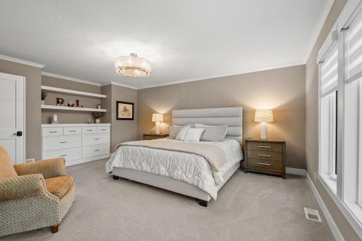 Luxurious Primary Suite w/ auto blinds, spa-like Bath w/ heated floors, freestanding tub, dual vanities & oversized WIC w/ organizational system + pass-through access to Laundry