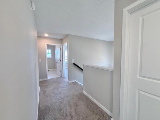 PHOTO OF A DIFFERENT HOME WITH SIMILAR PLAN. FINISHES MAY VARY. Upper floor hallway view.