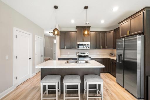 Stylish kitchen with dark cabinetry, stainless steel appliances, and a center island