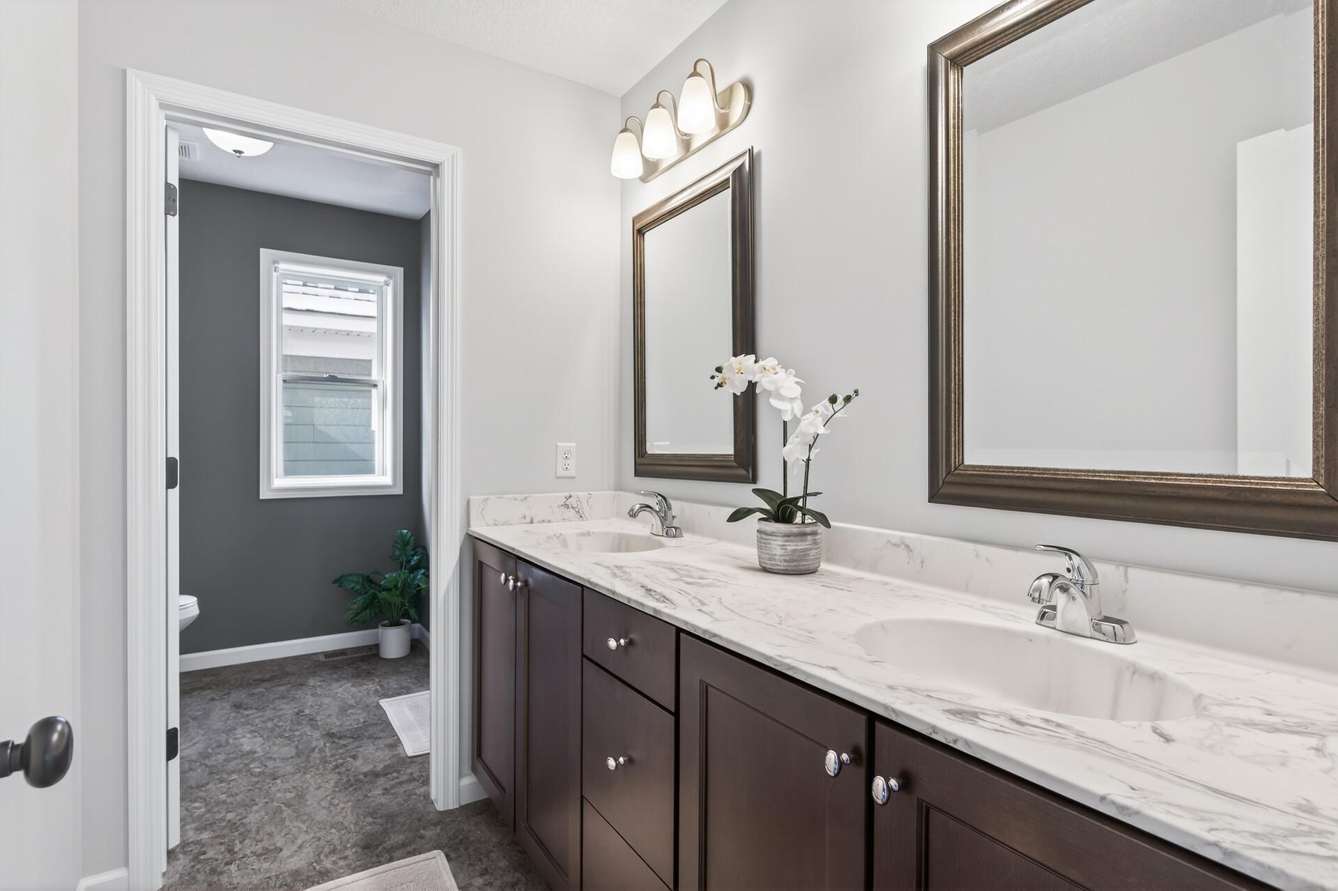 Upper level bathroom hosts double sinks and separate shower area