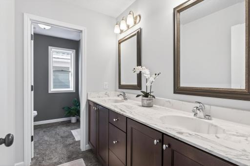 Upper level bathroom hosts double sinks and separate shower area