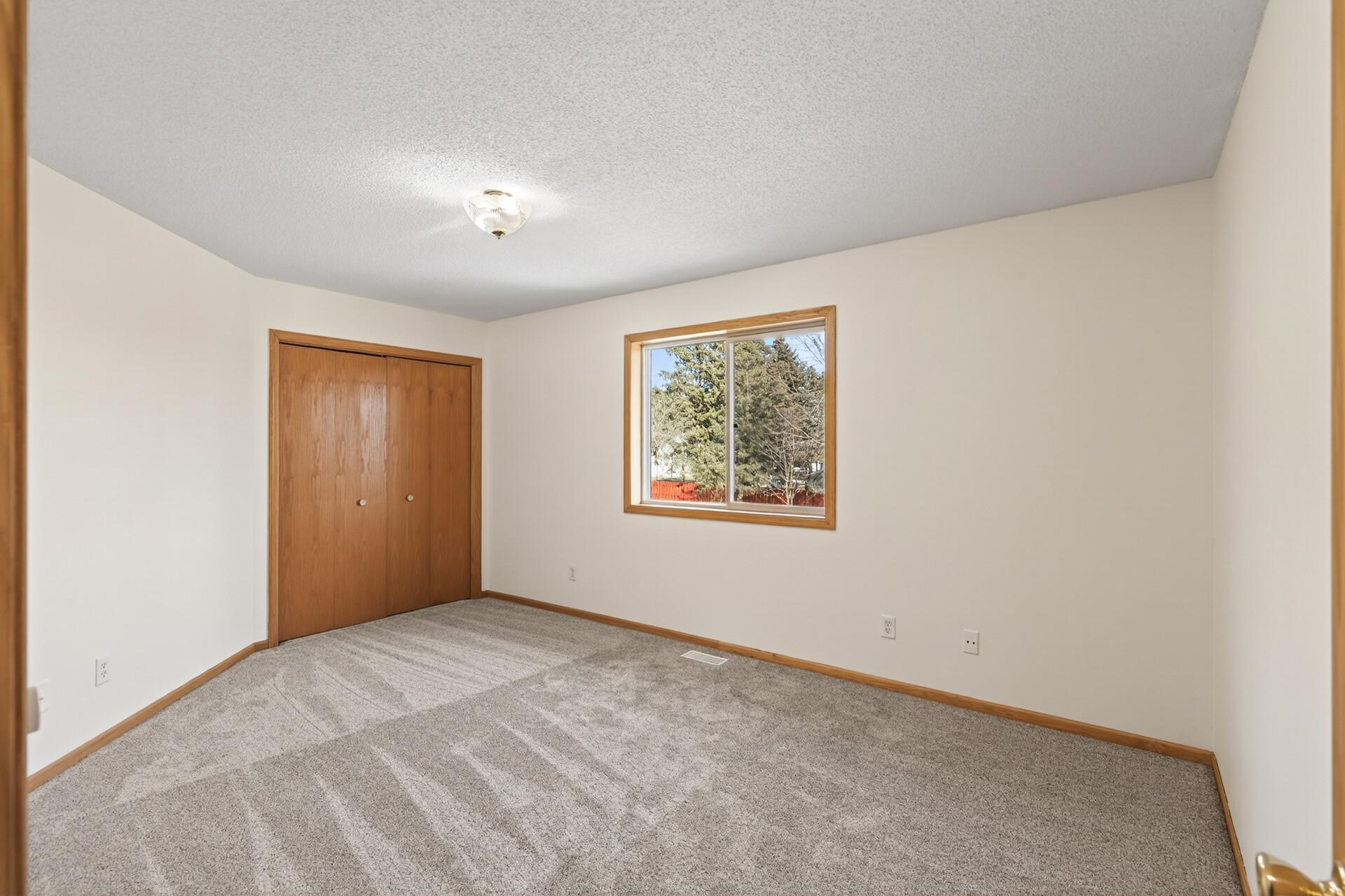 Spacious bedroom in upper level with new carpet.