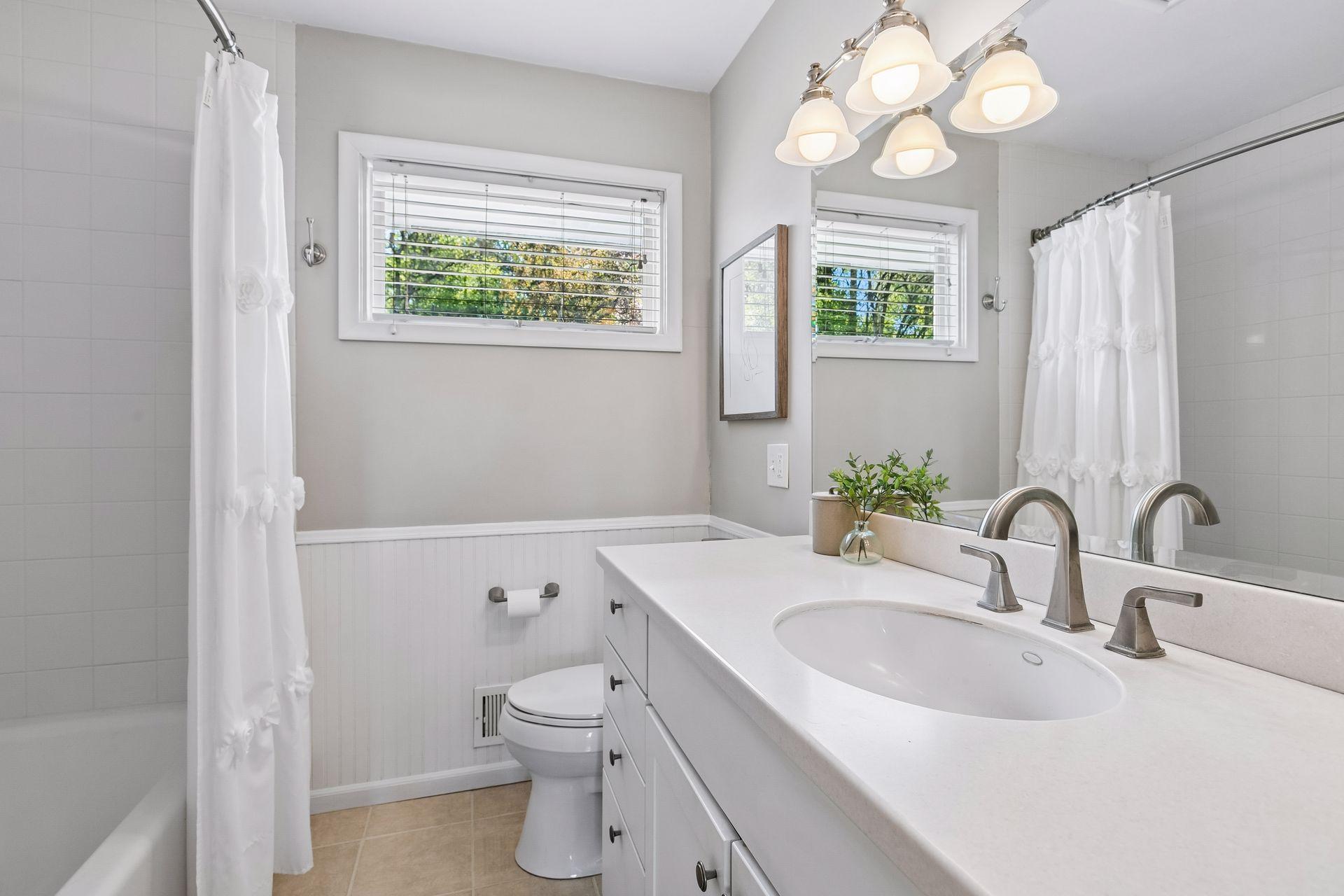 The main level is serviced by this spacious full bath with custom tilework.