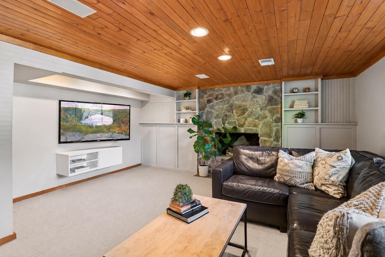 This wonderful space features a beautiful stone fireplace, recessed lighting, fun built-ins, and paneled ceilings.