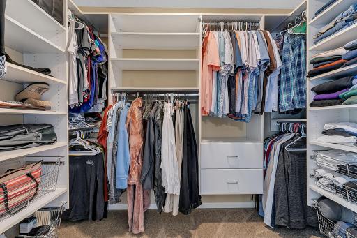Walk in closet with hanger space and built in shelving.