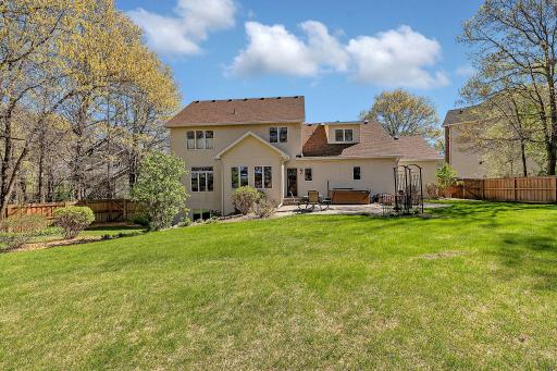 Back of home overlooks peaceful natural surroundings and mature trees.