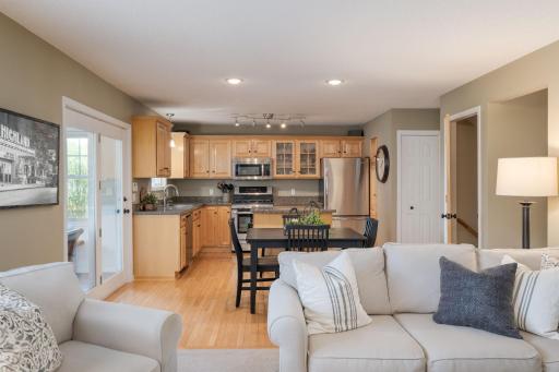 One glance captures the heart of this home: an open layout where the renovated kitchen, casual dining, and comfortable living room connect naturally under warm abundant light.