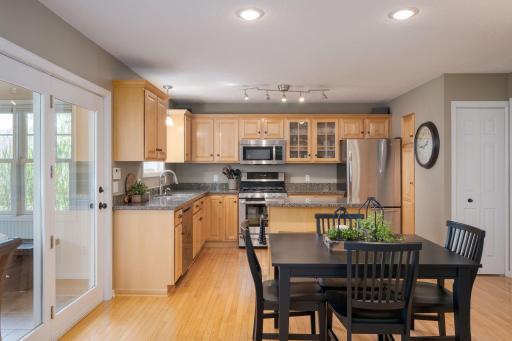 The renovated kitchen offers warm wood cabinetry, stainless appliances, and an open layout that flows naturally into a generous eat-in dining space, functional, welcoming, and ready for everyday life.