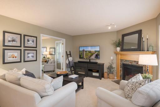 The family room invites you to settle in. A stone fireplace, generous seating, and a warm neutral palette create a space that feels lived in and loved from day one.