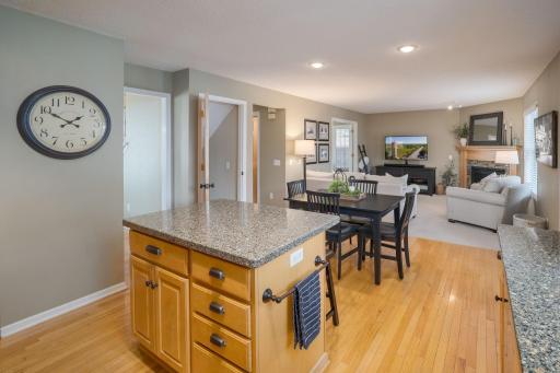 From the granite island to the dining table to the fireplace family room, this view captures the effortless flow that makes the main level enjoyable to live in.