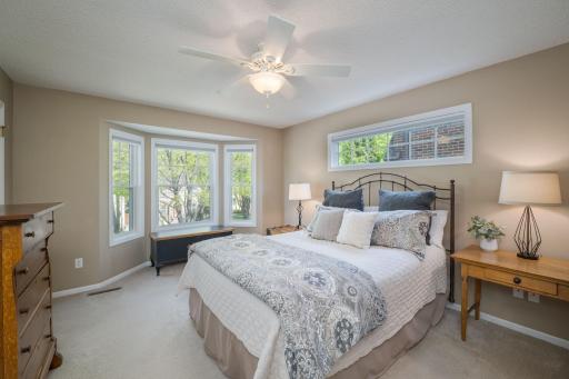 The primary suite is serene and beautifully lit. It's a true sanctuary, wrapped in treetop views from multiple windows bathed in natural light.