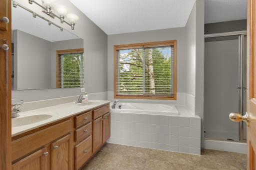 Luxurious ensuite with soaking tub, walk-in shower, and dual sink vanity.