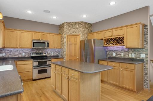 Well-appointed gourmet kitchen with Corian countertops, tile backsplash, stainless steel appliances, and ample cabinetry.