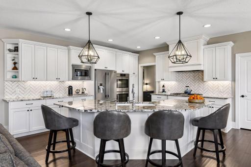 A Chef's dream! The well-equipped kitchen features custom cabinetry with soft-close drawers and doors and quartzite countertops.