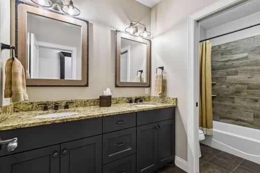 A full Bathroom completes the lower level with a comfort-height vanity featuring granite countertops, Moen fixtures and a tiled bathtub and shower surround.