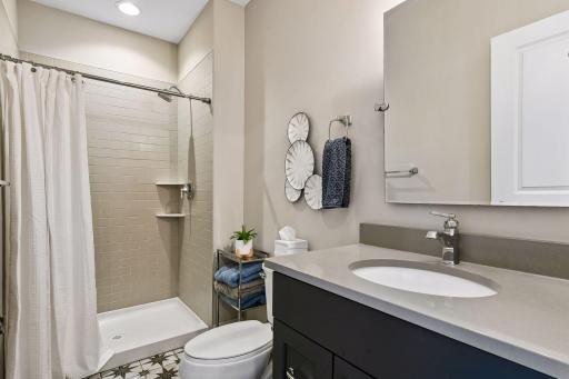 This bedroom enjoys a private 3/4 en suite bathroom with comfort-height vanity and tiled shower.