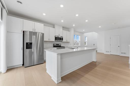 At the focal point of this modern kitchen is a quartz-topped center island to add bar-style seating, complemented by extensive cabinetry room and all-new stainless steel appliances to craft delicious meals.