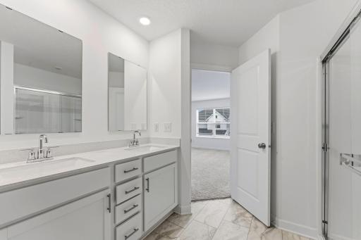 Quartz countertops, MoenÂ® Glyde faucets and dual sinks come together at this impressive vanity