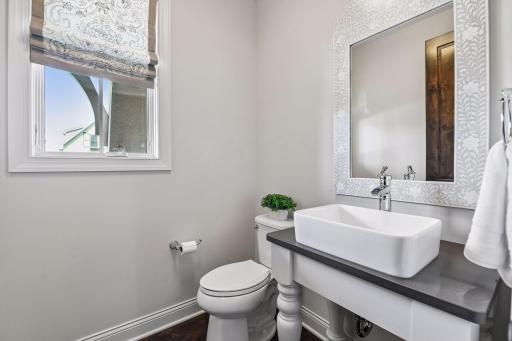 Half bath on main with custom pedestal vanity located right off back hall and tucked around front entry way.