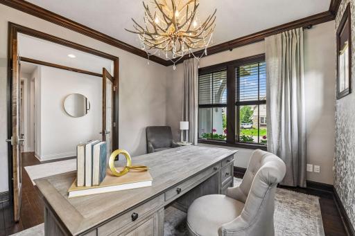Imagine sitting here as your home office. Big picture window to the front yard, nice transom windows behind for extra light with view to half bathroom and drop zone out the French doors.