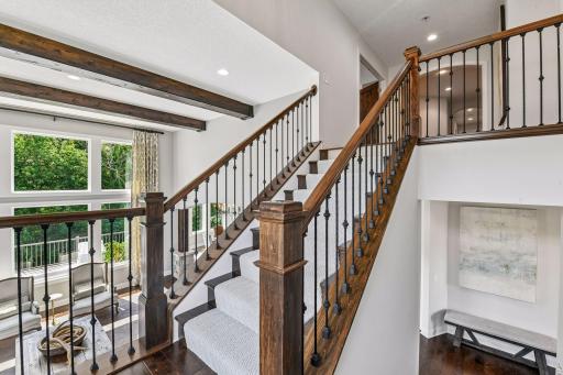 Wood staircase with rod iron spindles as you enter the upper level.