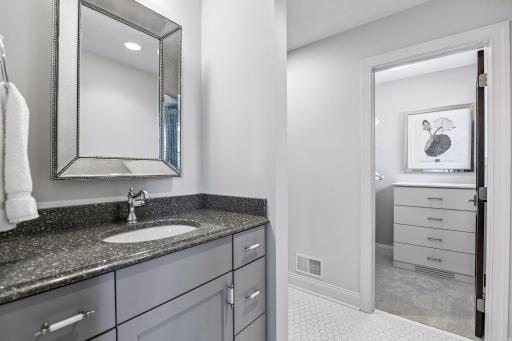 Ensuite bathroom with tile floors, granite counter, spacious walk-in closet and tile surround shower