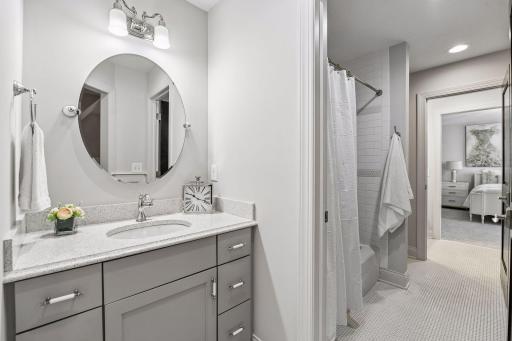 Pass through tiled bathroom located between 2 of the 4 upper bedrooms. Separate vanity area and shared shower/tub and stool with doors between for privacy.