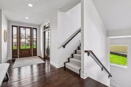 Welcome to your custom-built home that feels like new. Gorgeous hand scraped hardwood floors on main. French doors in photo are the entry to your main level home office.
