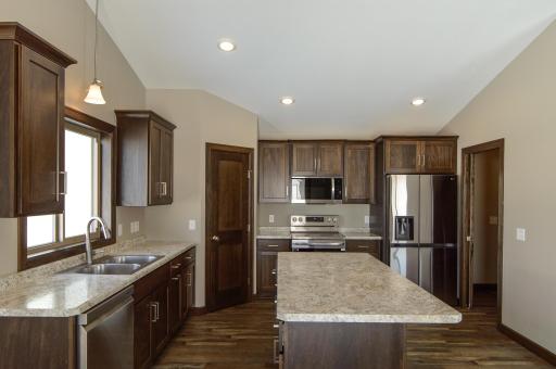 Well equipped kitchen with stainless steel appliance, large pantry & center island ~ new to this layout is a solid surface countertop option included as standard!