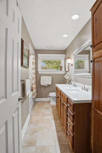 Light-filled main level bathroom with quartz countertops and heated flooring.