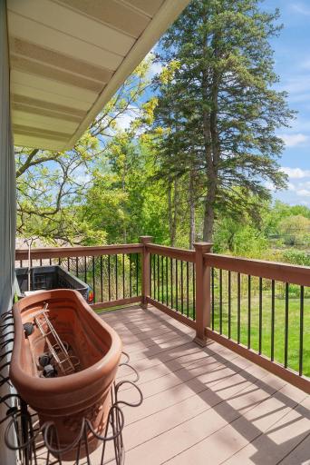 Step out to a private deck overlooking the serene backyard and neighboring pond.