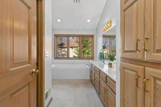 Primary bathroom with double sinks, separate tub and shower plus walk-in closet