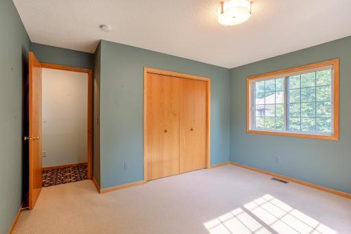 Spacious secondary bedroom featuring oversized windows and a functional layout ideal for family, guests, or a home office.